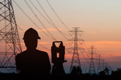 silhouette black man survey and civil engineer stand on ground working in a land building site over Blurred construction worker on construction site. examination, inspection, survey